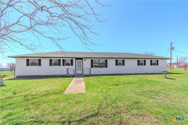 ranch-style home featuring a front yard, fence, and brick siding