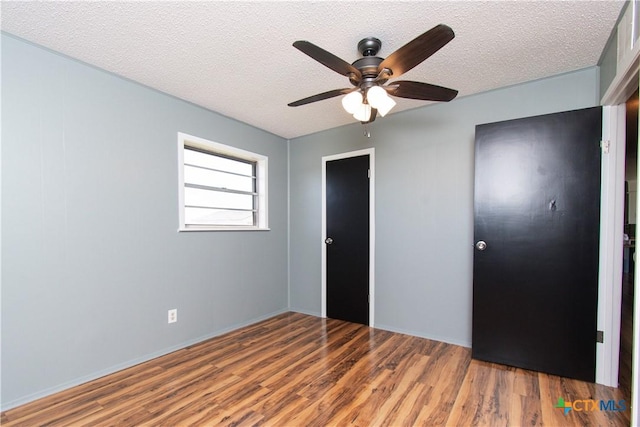 unfurnished bedroom featuring a textured ceiling, wood finished floors, and a ceiling fan