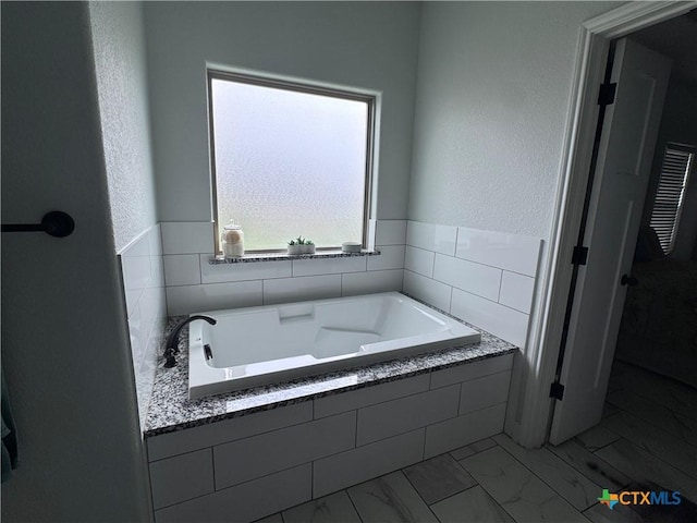 3220 Wild Seed Dr, Salado, TX 76571 - bathroom with marble finish floor, a textured wall, and a bath