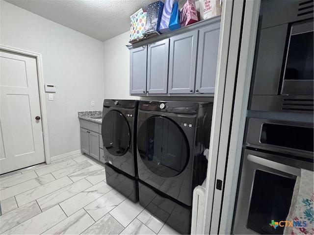 3220 Wild Seed Dr, Salado, TX 76571 - washroom with a textured ceiling, baseboards, marble finish floor, cabinet space, and washing machine and dryer
