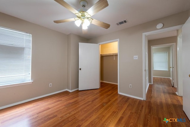 402 N Fredericksburg St Unit 9, San Marcos, TX 78666 - unfurnished bedroom with light wood-style flooring, a spacious closet, ceiling fan, and a closet