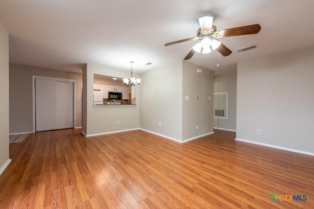 402 N Fredericksburg St Unit 9, San Marcos, TX 78666 - unfurnished living room with a chandelier, a ceiling fan, and light wood-type flooring
