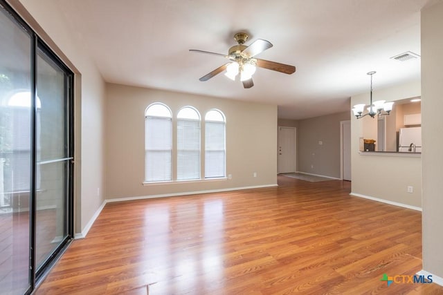 402 N Fredericksburg St Unit 9, San Marcos, TX 78666 - unfurnished living room featuring a ceiling fan, a chandelier, and light wood-style flooring