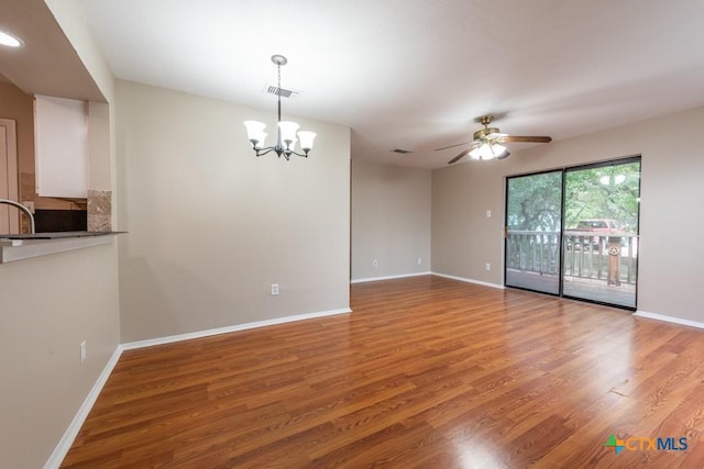 402 N Fredericksburg St Unit 9, San Marcos, TX 78666 - spare room featuring wood finished floors, a chandelier, and ceiling fan