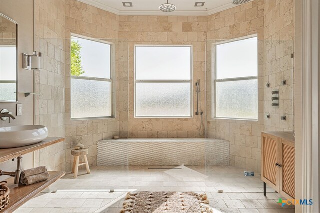 200 Tovas Secret Cv, Georgetown, TX 78628 - bathroom featuring a sink, crown molding, a tile shower, and tile walls