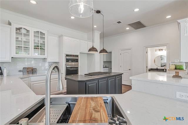 200 Tovas Secret Cv, Georgetown, TX 78628 - kitchen with appliances with stainless steel finishes, ornamental molding, white cabinets, hanging light fixtures, and glass insert cabinets