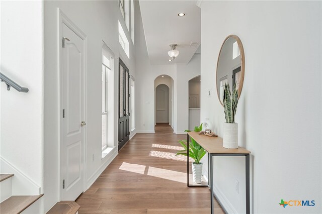 200 Tovas Secret Cv, Georgetown, TX 78628 - hall featuring arched walkways, light wood finished floors, recessed lighting, and baseboards