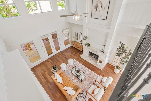 200 Tovas Secret Cv, Georgetown, TX 78628 - living area with a high ceiling, healthy amount of natural light, wood finished floors, a ceiling fan, and a fireplace with raised hearth