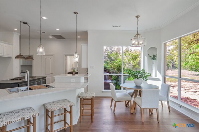200 Tovas Secret Cv, Georgetown, TX 78628 - kitchen with dark wood-type flooring, white cabinetry, recessed lighting, a kitchen breakfast bar, and hanging light fixtures