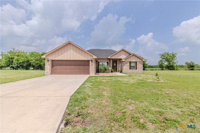 7112 Kc Ranch Ct, Temple, TX 76501 - ranch-style house with a garage, driveway, a front lawn, and brick siding