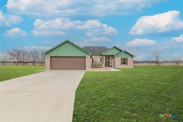 view of front of property with driveway, brick siding, an attached garage, and a front yard