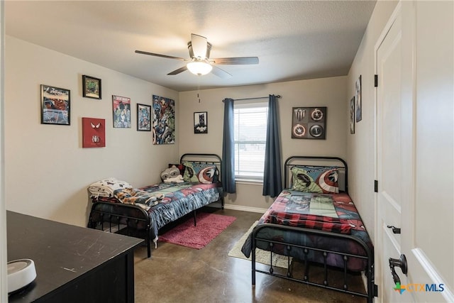 bedroom featuring concrete flooring, ceiling fan, a textured ceiling, and baseboards