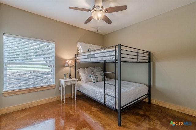 bedroom with ceiling fan, baseboards, and finished concrete floors