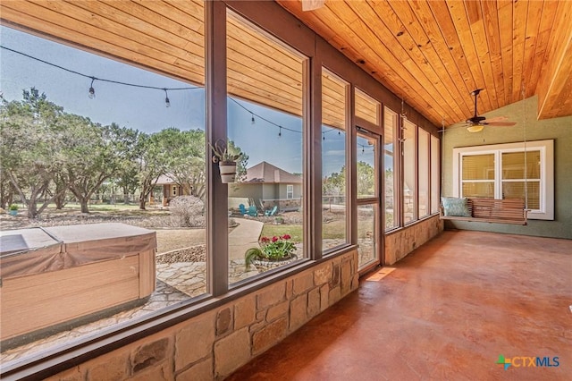 unfurnished sunroom featuring lofted ceiling, wood ceiling, and a ceiling fan