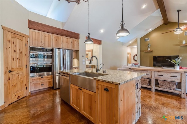 kitchen with light stone countertops, open floor plan, beam ceiling, stainless steel appliances, and a sink