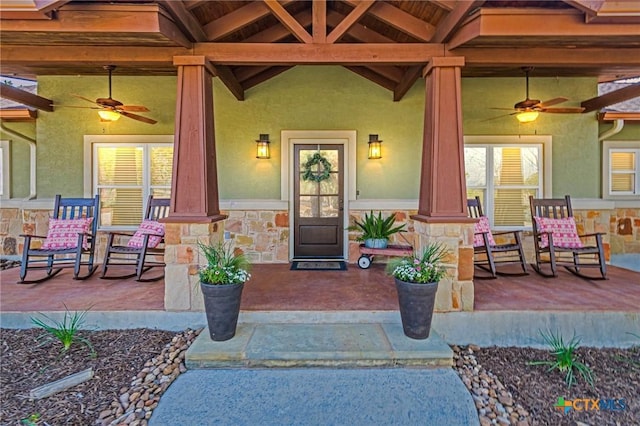 entrance to property featuring stucco siding, stone siding, and a porch