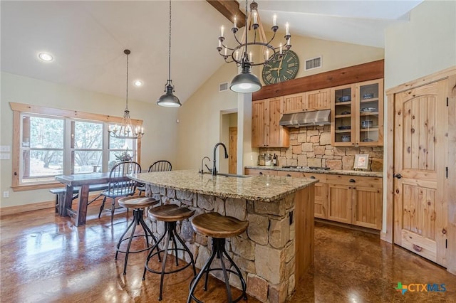 kitchen with under cabinet range hood, finished concrete floors, tasteful backsplash, and a sink