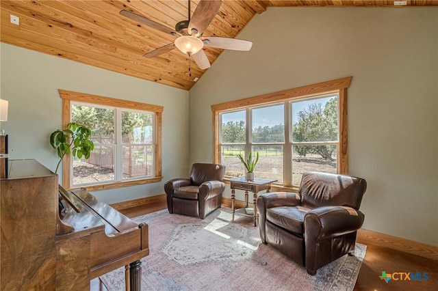 living area with high vaulted ceiling, wooden ceiling, baseboards, and ceiling fan