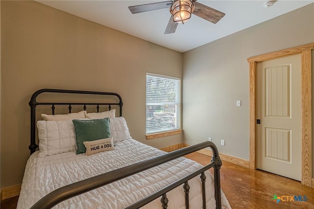 bedroom with a ceiling fan, baseboards, and concrete flooring