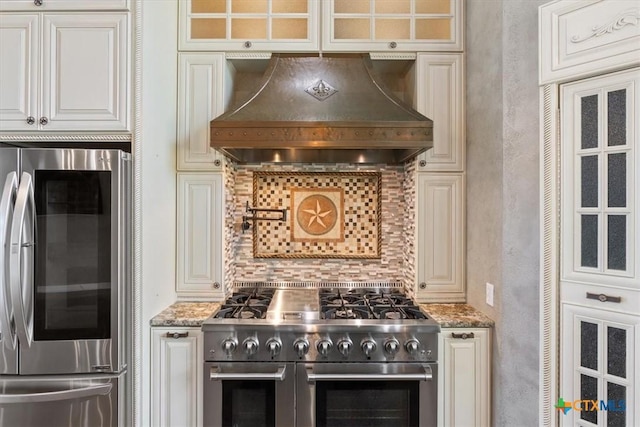 343 Riverside Dr, Killeen, TX 76542 - kitchen with stainless steel appliances, custom exhaust hood, decorative backsplash, glass insert cabinets, and light stone countertops