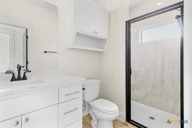 bathroom featuring toilet, an enclosed shower, vanity, and hardwood / wood-style flooring