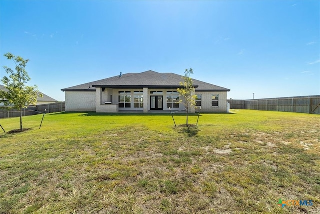 back of house with a lawn and a patio area