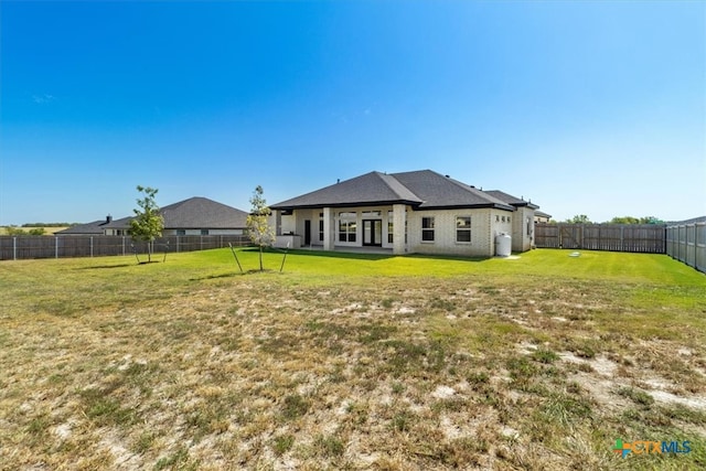 back of house with a lawn