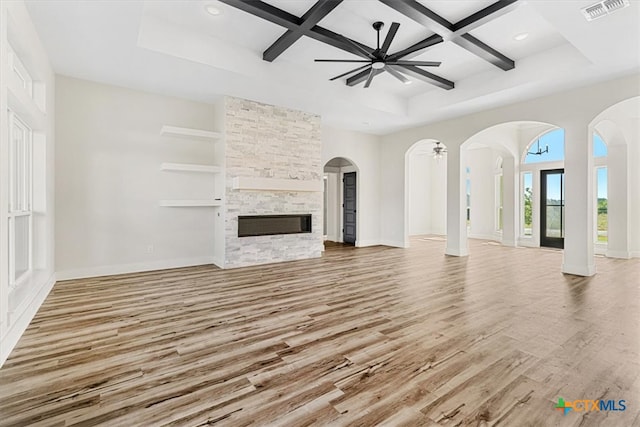 unfurnished living room featuring a fireplace, light hardwood / wood-style floors, beamed ceiling, and coffered ceiling