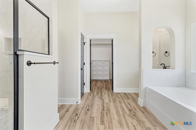 bathroom with wood-type flooring and separate shower and tub