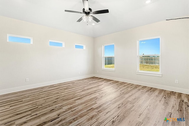 empty room with ceiling fan and light hardwood / wood-style flooring