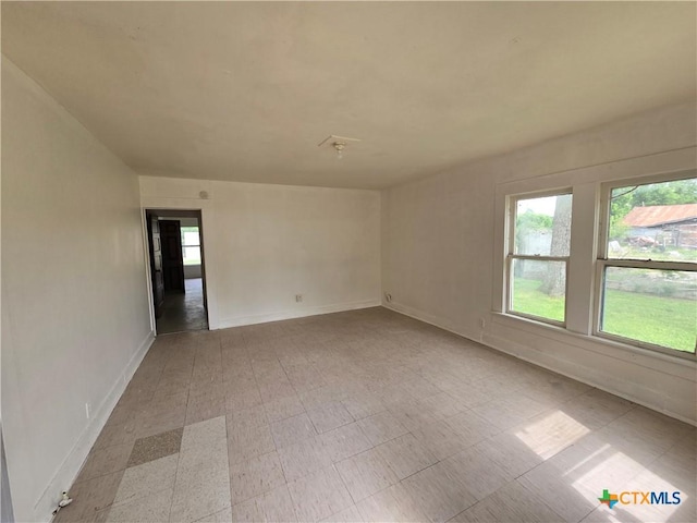 unfurnished room with baseboards and light floors