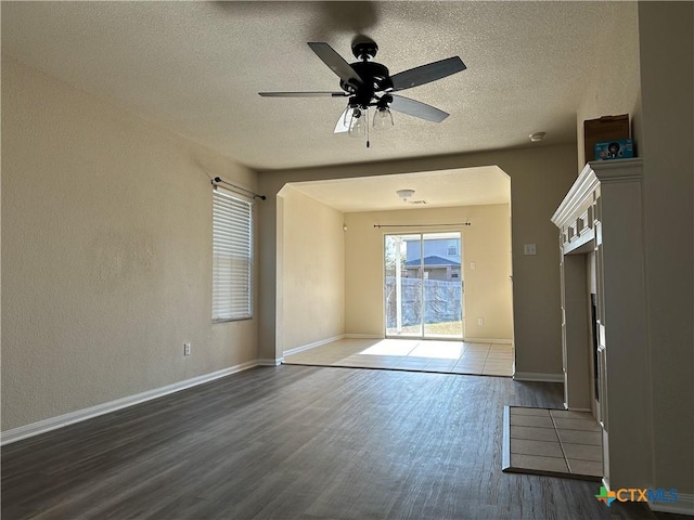 spare room with a textured ceiling, dark hardwood / wood-style flooring, and ceiling fan