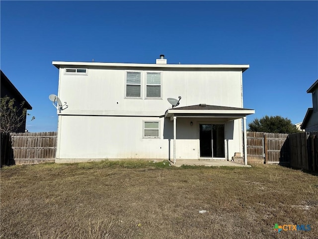 back of house featuring a patio and a lawn