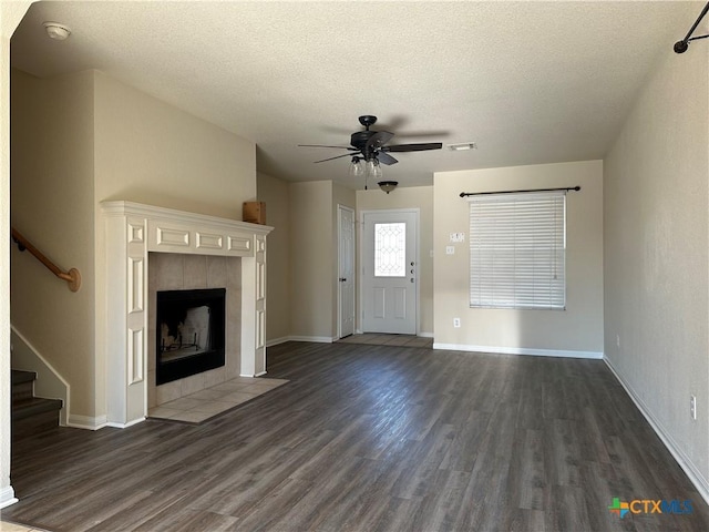 unfurnished living room with a fireplace, a textured ceiling, dark hardwood / wood-style floors, and ceiling fan