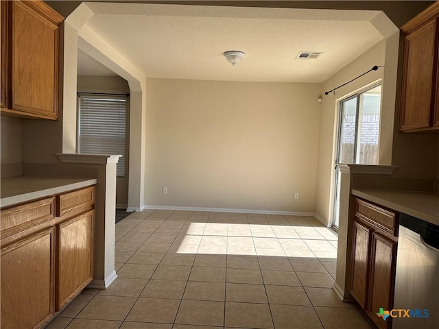 kitchen with dishwasher, light tile patterned floors, and a textured ceiling