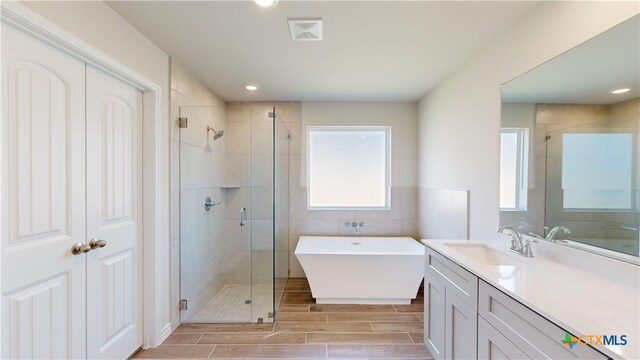 609 Waylon Cir, Killeen, TX 76542 - full bath with a soaking tub, a stall shower, vanity, wood finish floors, and tile walls