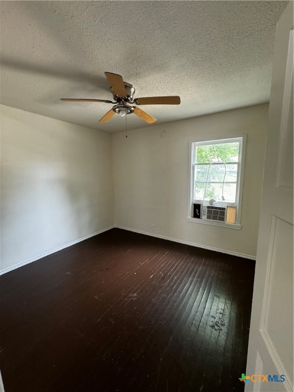 spare room with ceiling fan, cooling unit, a textured ceiling, and dark hardwood / wood-style floors