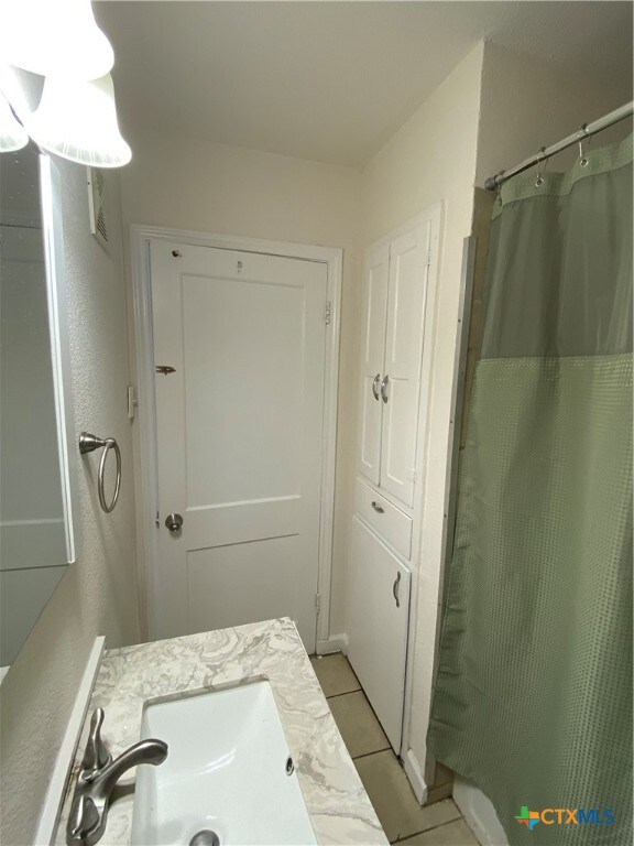 bathroom featuring vanity, tile patterned floors, and curtained shower