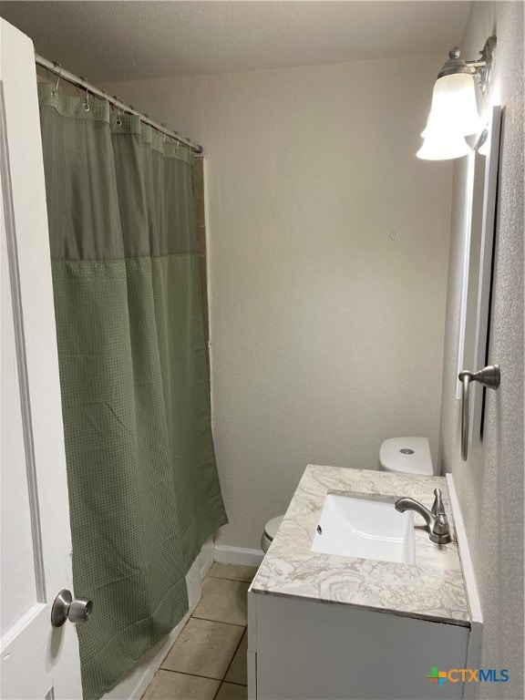 bathroom with toilet, vanity, tile patterned flooring, and curtained shower