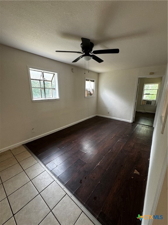 spare room featuring wood-type flooring, ceiling fan, and a textured ceiling