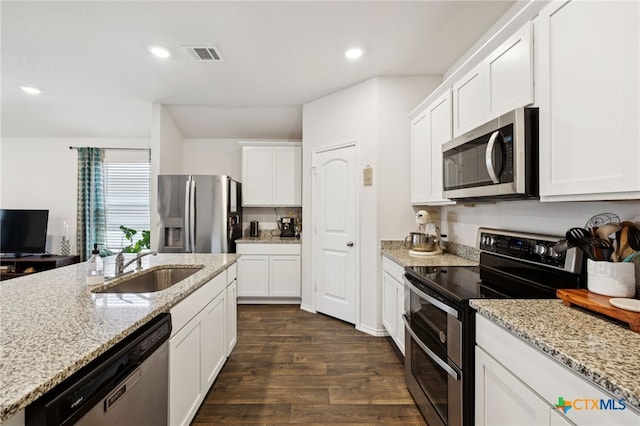 1004 Norway Dr, Seguin, TX 78155 - kitchen featuring stainless steel appliances, dark wood-type flooring, white cabinets, light stone countertops, and recessed lighting