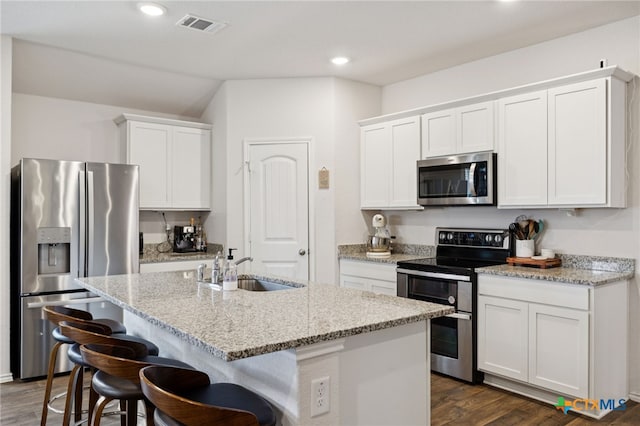 1004 Norway Dr, Seguin, TX 78155 - kitchen featuring appliances with stainless steel finishes, dark wood finished floors, an island with sink, white cabinets, and recessed lighting