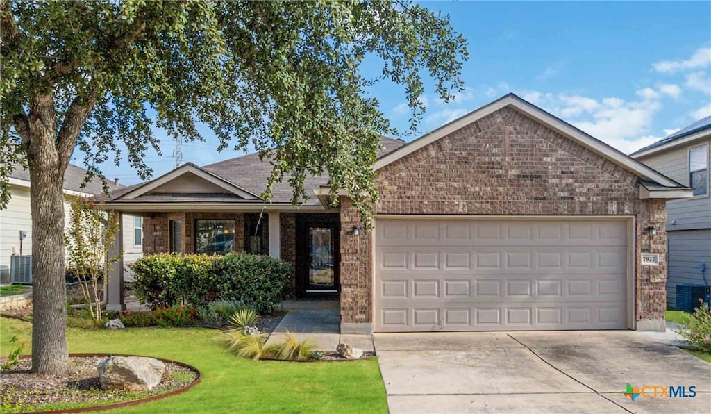 view of front of property featuring central AC, a front lawn, and a garage