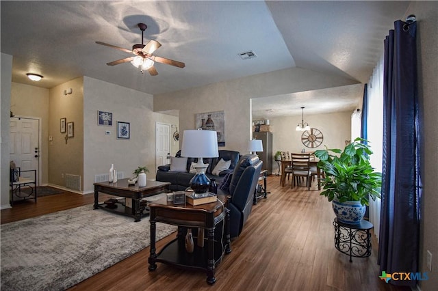 living room featuring visible vents, wood finished floors, ceiling fan, and vaulted ceiling