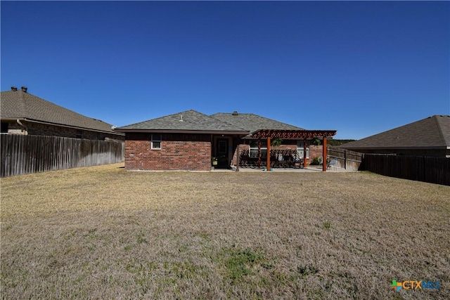 back of property featuring a pergola, a fenced backyard, a yard, brick siding, and a patio area