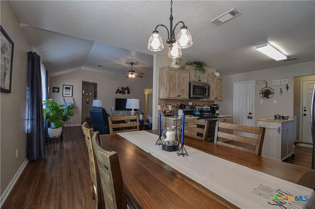 dining area featuring visible vents, baseboards, dark wood finished floors, ceiling fan with notable chandelier, and a textured ceiling