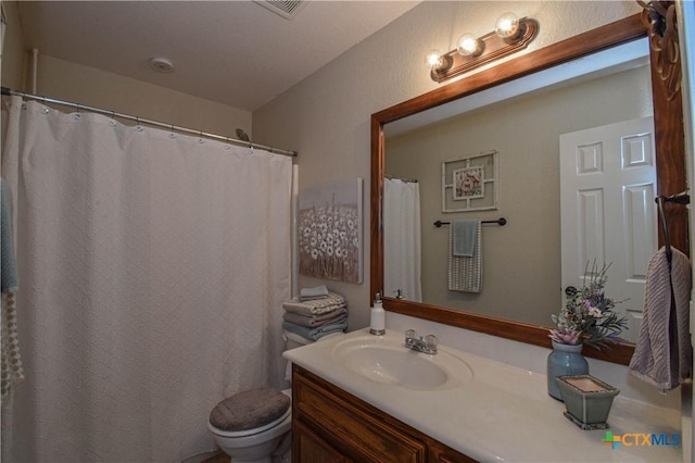 full bathroom featuring vanity, toilet, and visible vents