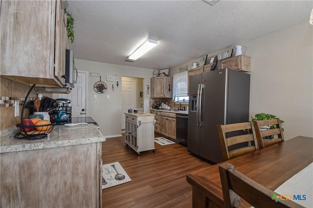 kitchen featuring a sink, appliances with stainless steel finishes, light countertops, decorative backsplash, and dark wood-style flooring