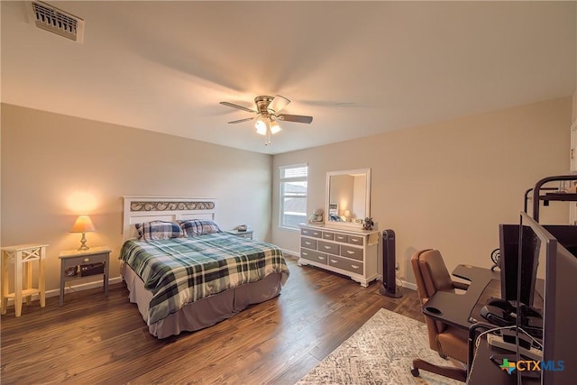 bedroom featuring baseboards, wood finished floors, visible vents, and a ceiling fan