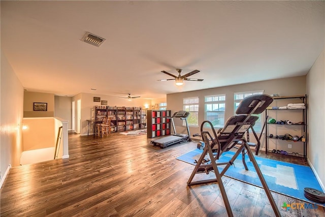 workout area featuring visible vents, baseboards, wood finished floors, and ceiling fan